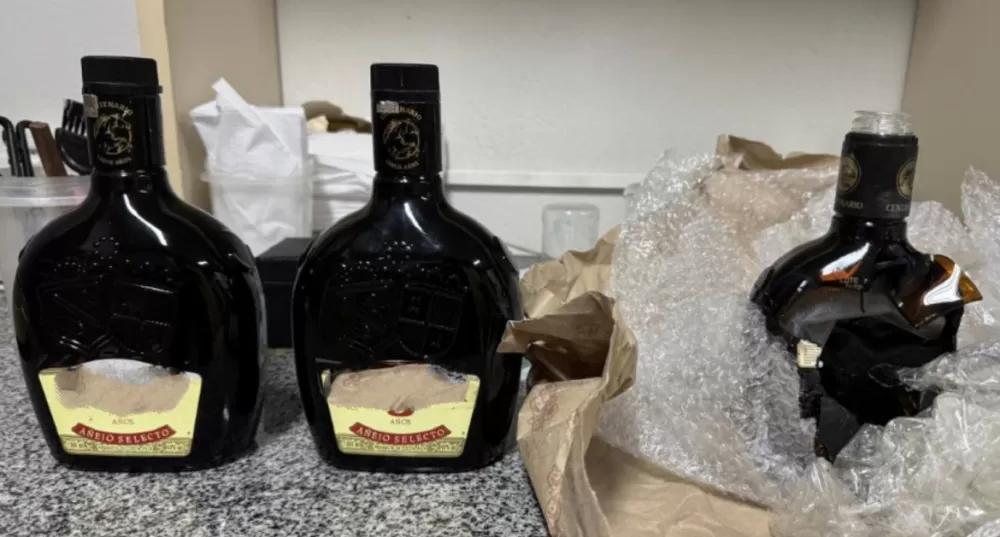 Jovem é preso com cocaína líquida escondida em garrafas de rum no Aeroporto do Recife.