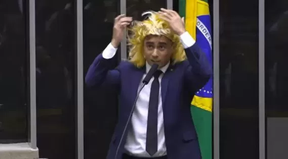 Justiça condena Nikolas Ferreira a pagar indenização de R$ 200 mil após episódio com peruca na Câmara.