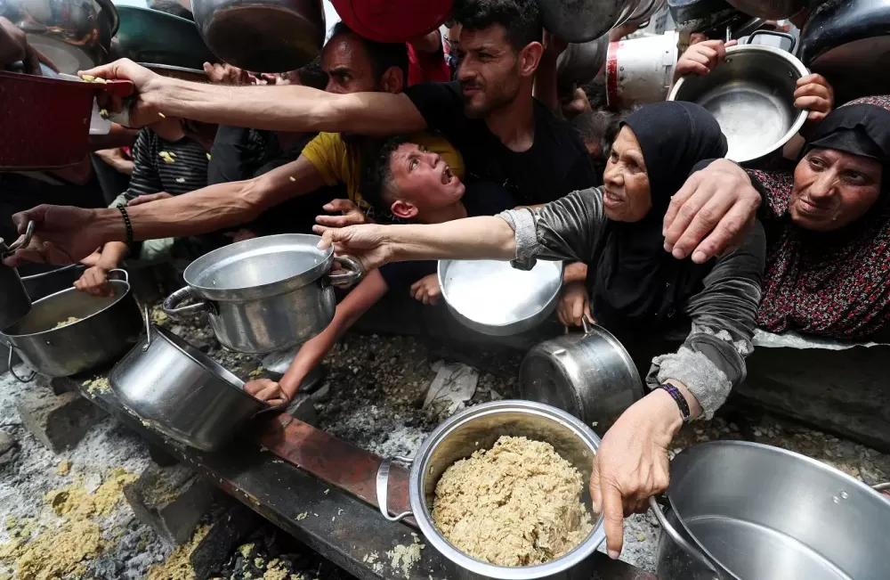 Palestinos famintos invadem centro de distribuição de comida em Gaza.