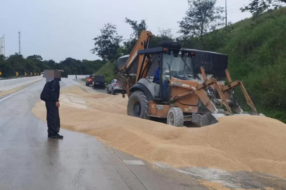 Caminhão transportando cevada bate em mureta e a carga gera interdição em trecho da BR-101
